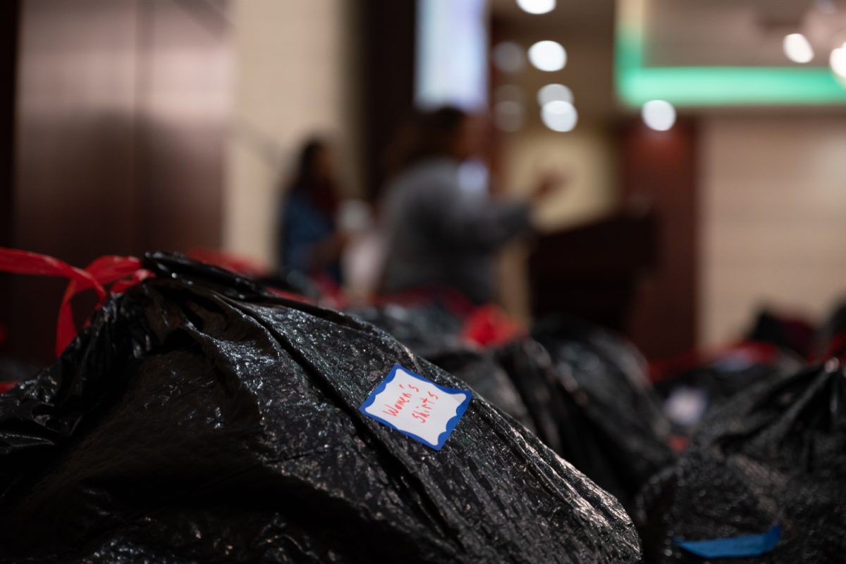 A bag filled with women's shirts sits amongst dozens of other bags of donated clothing for the Homeward Alliance as volunteers take a break.