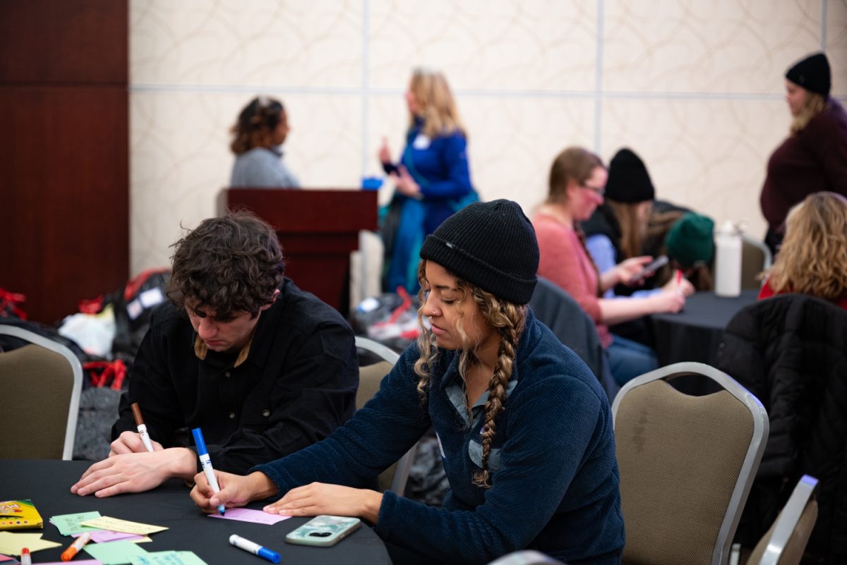 BIPOC Alliance member Olivia Cole, who works with Colorado State University's study abroad program, writes a note of encouragement to go alongside the clothing donations for Homeward Alliance at the Day of Service for Martin Luther King Jr. Day.