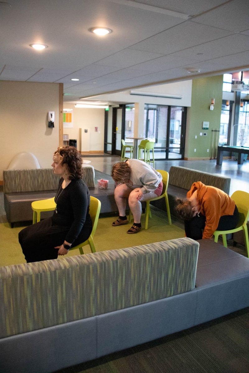 Torin Pruneski, Megan Petersen and Eve Montoya stretch during seated wheelchair accessible yoga in the Aggie Village Lodgepole lobby on January 29, 2024.