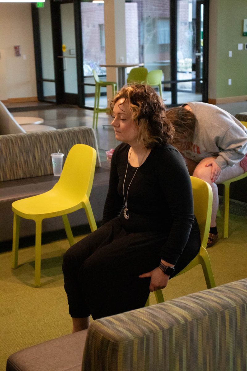 Eve Montoya stretches during seated wheelchair accessible yoga in the Aggie Village Lodgepole lobby on January 29, 2024.