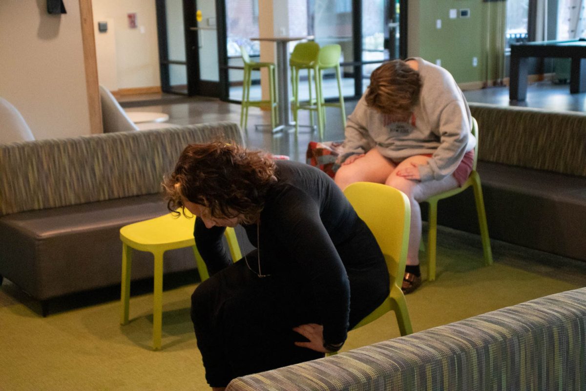 Eve Montoya stretches during seated wheelchair accessible yoga in the Aggie Village Lodgepole lobby on January 29, 2024.