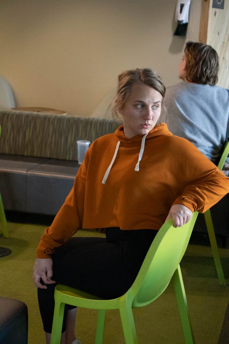 Megan Petersen stretches during seated wheelchair accessible yoga in the Aggie Village Lodgepole lobby on January 29, 2024.