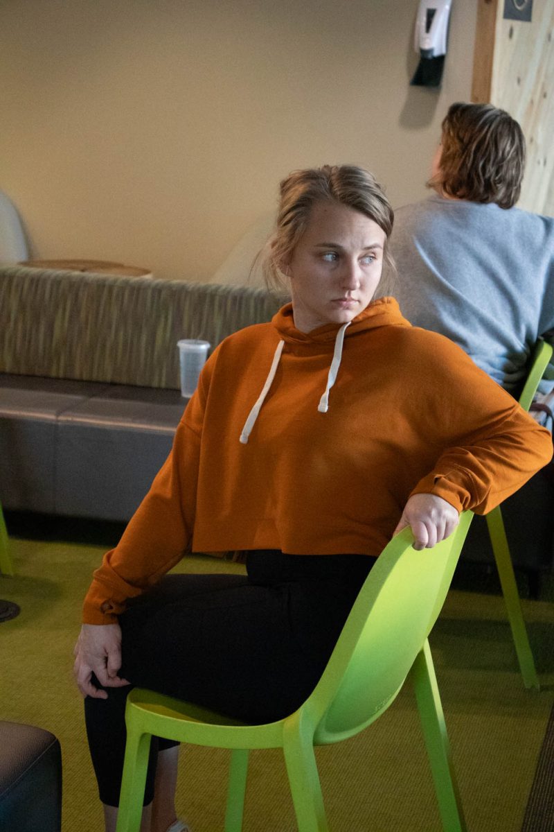 Megan Petersen stretches during seated wheelchair accessible yoga in the Aggie Village Lodgepole lobby on January 29, 2024.
