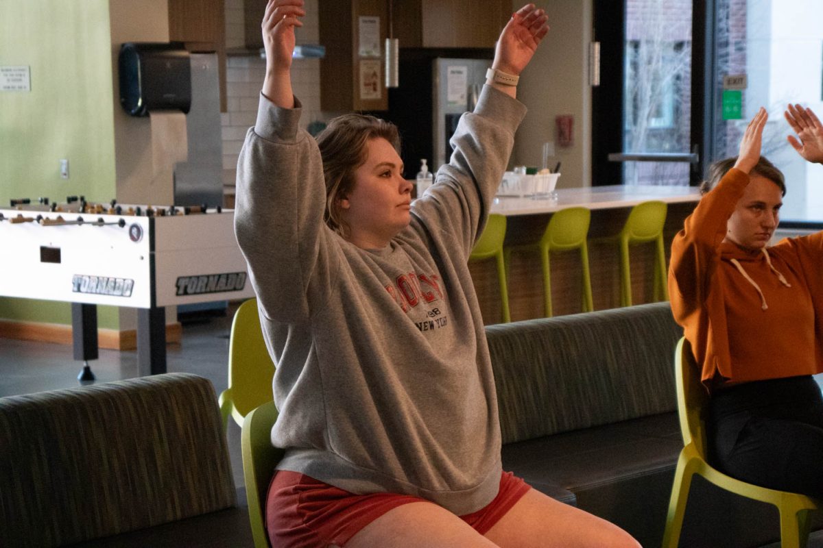 Torin Pruneski, a graduate student and Colorado State University staff member, stretches during seated wheelchair accessible yoga in the Aggie Village Lodgepole lobby on January 29, 2024.