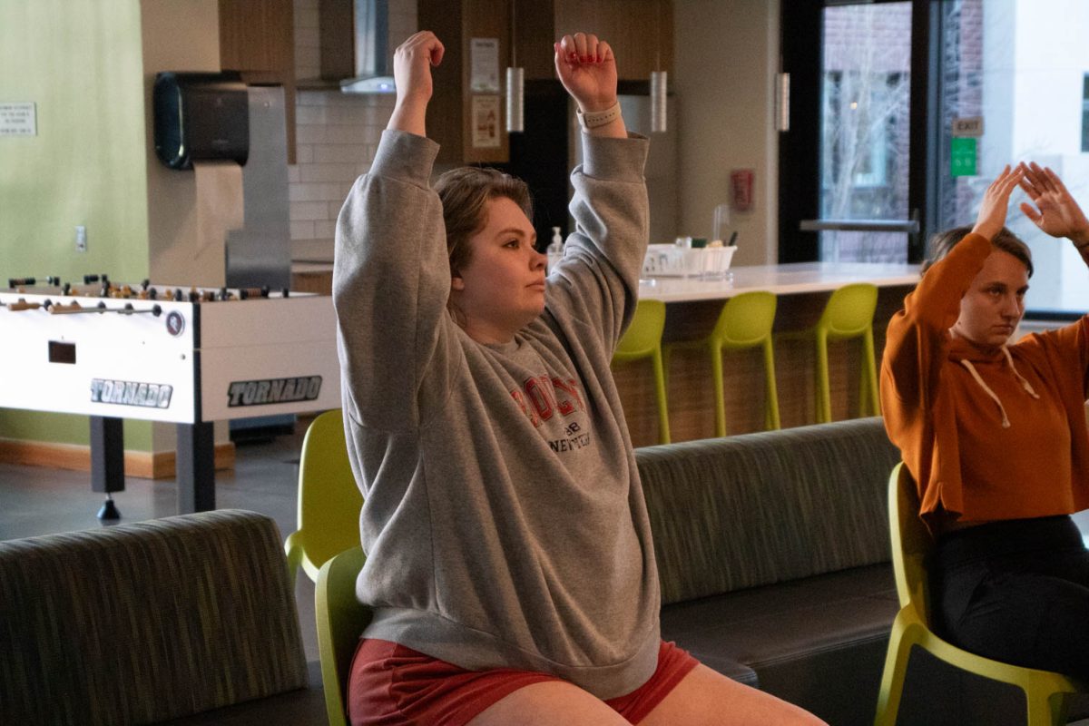 Torin Pruneski, a graduate student and Colorado State University staff member, stretches during seated wheelchair accessible yoga in the Aggie Village Lodgepole lobby on January 29, 2024.