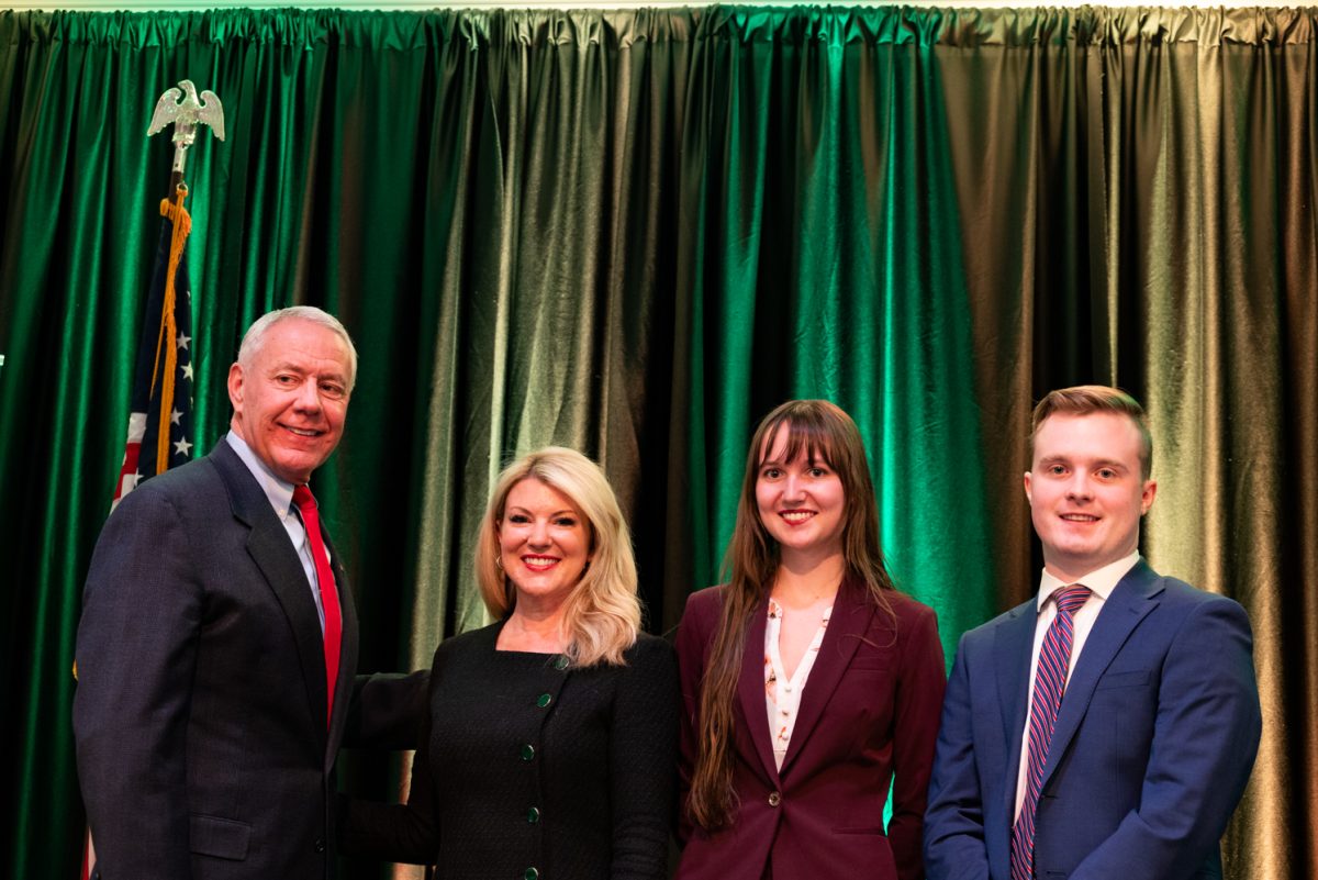 Representative Ken Buck, Colorado State University President Amy Parsons, and student moderators Amber Wright and Jack Barrett smile for a picture after the Coffee with Ken Buck event.