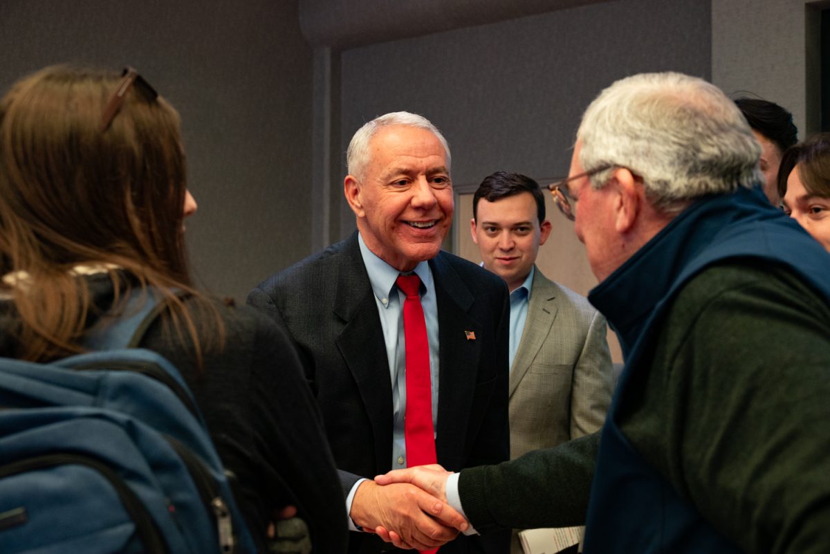 Representative Ken Buck smiles and shakes an audience member's hand after the Coffee with Ken Buck event in the University Ballroom.