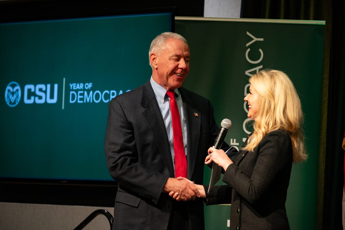 Colorado State University President Amy Parsons shakes Representative Ken Buck's hand at the Coffee with Ken Buck event in the University Ballroom of the Lory Student Center.