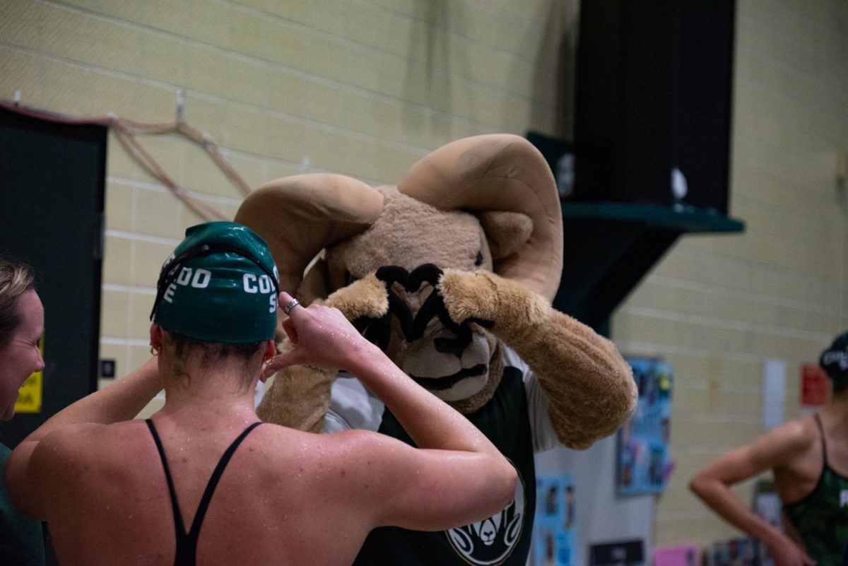 A Colorado State University swimmer makes a heart at Cam the Ram before the start of the meet against the University of Northern Colorado.