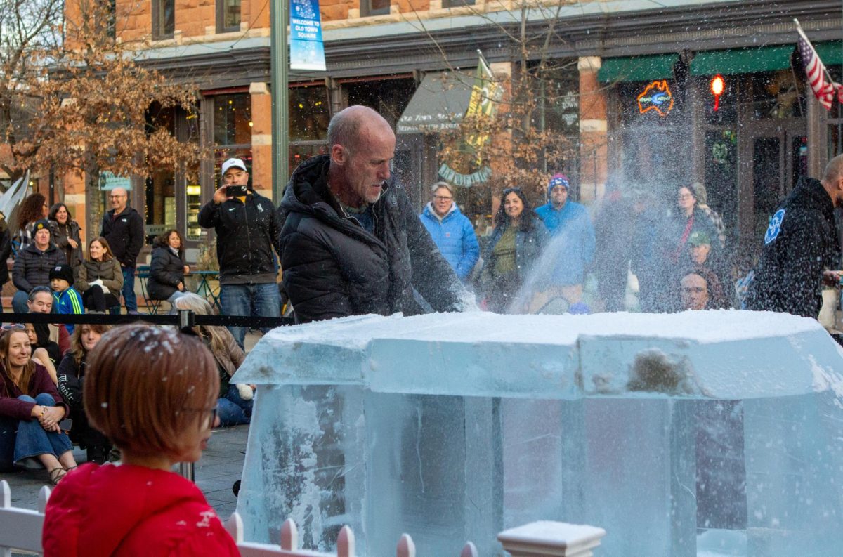 Ice carver Thomas Barlow uses a chainsaw to cut through thick ice and smooth the edges of his igloo in Old Town Fort Collins on Feb. 2, 2024. 