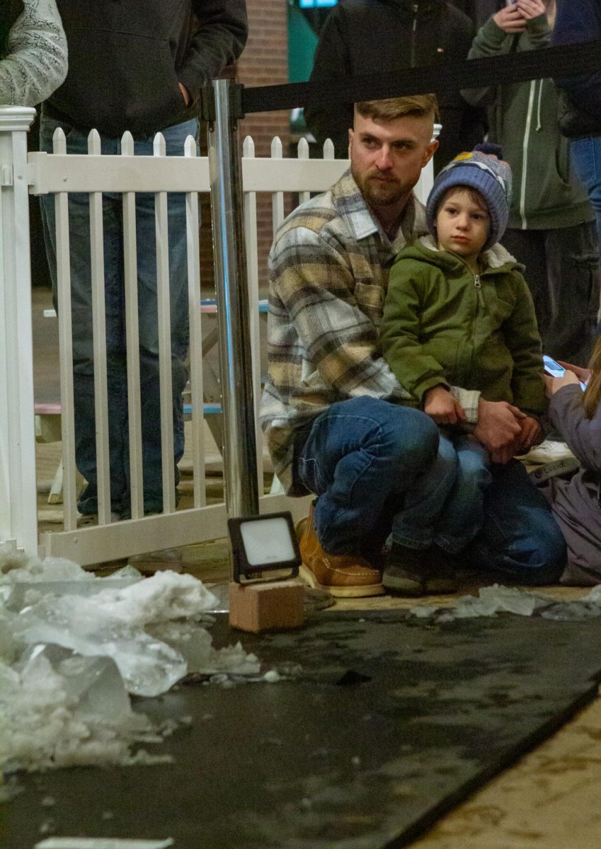 A child and his guardian watch while Thomas Barlow carves his ice sculpture in Old Town Fort Collins, CO on Feb. 2. 