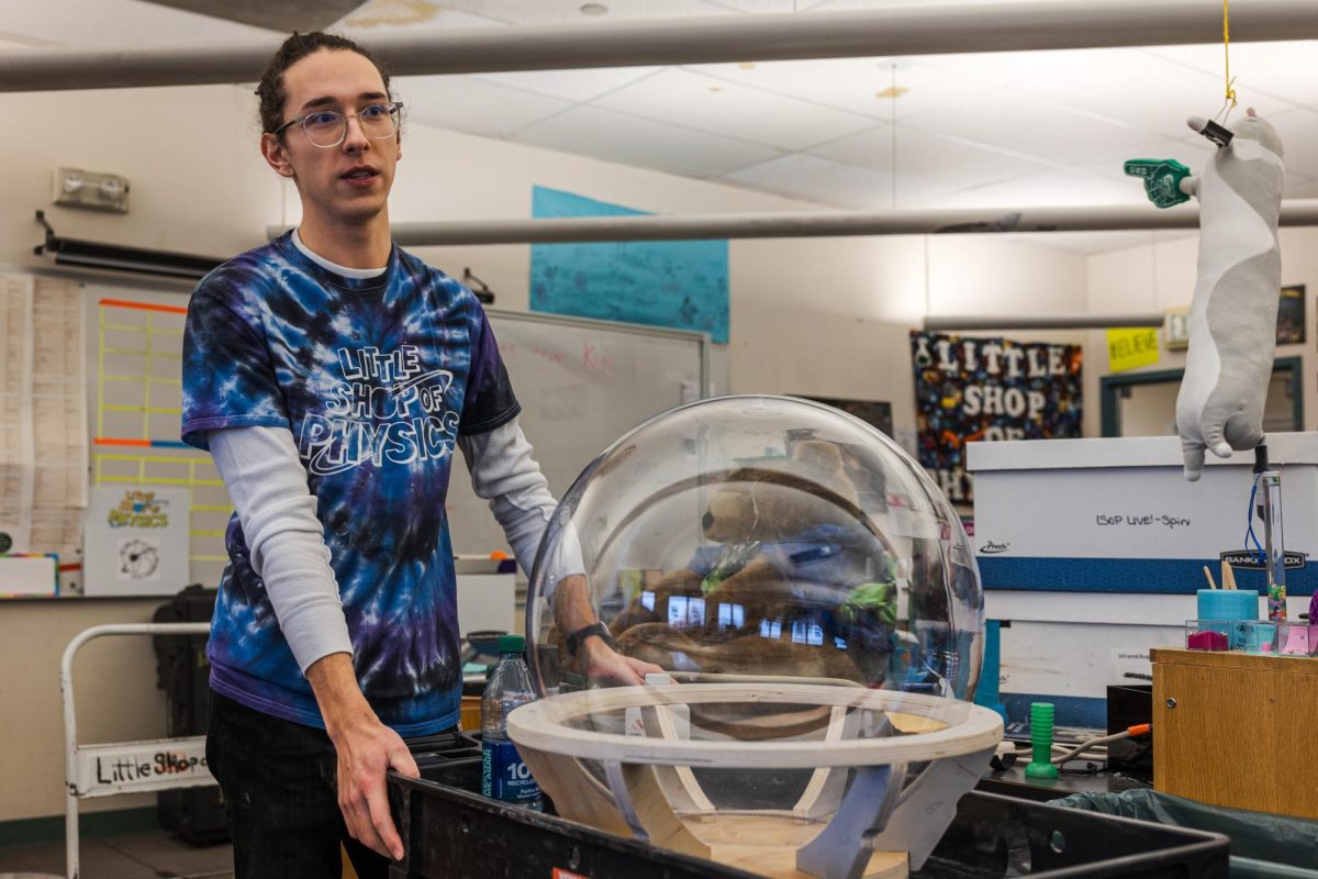 Little Shop of Physics student intern Mason McClellan showcases an in-progress Jupiter jar Feb. 15. The jar is filled with fluid that can simulate storms on Jupiter, according to Teacher in Residence Cherie Bornhorst.