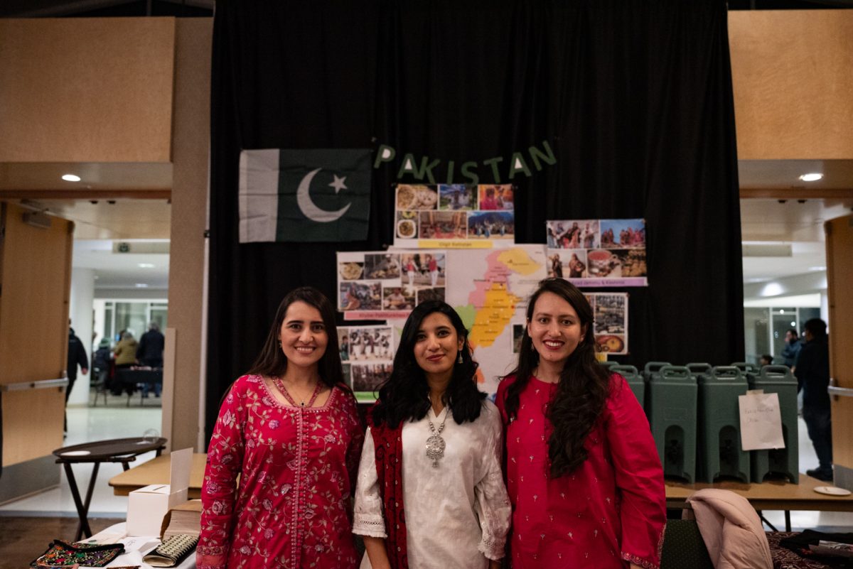 Mutahir Sultan, Saira Jabeen, and Arifa Shabnum smile for a photo at their Pakistan booth at the World Unity Fair Feb. 17. "People who came here asked us different questions about Pakistan and it was really interesting telling them about Pakistan that they didn't know," Shabnum said. "It was a good experience, exchanging information with other people."