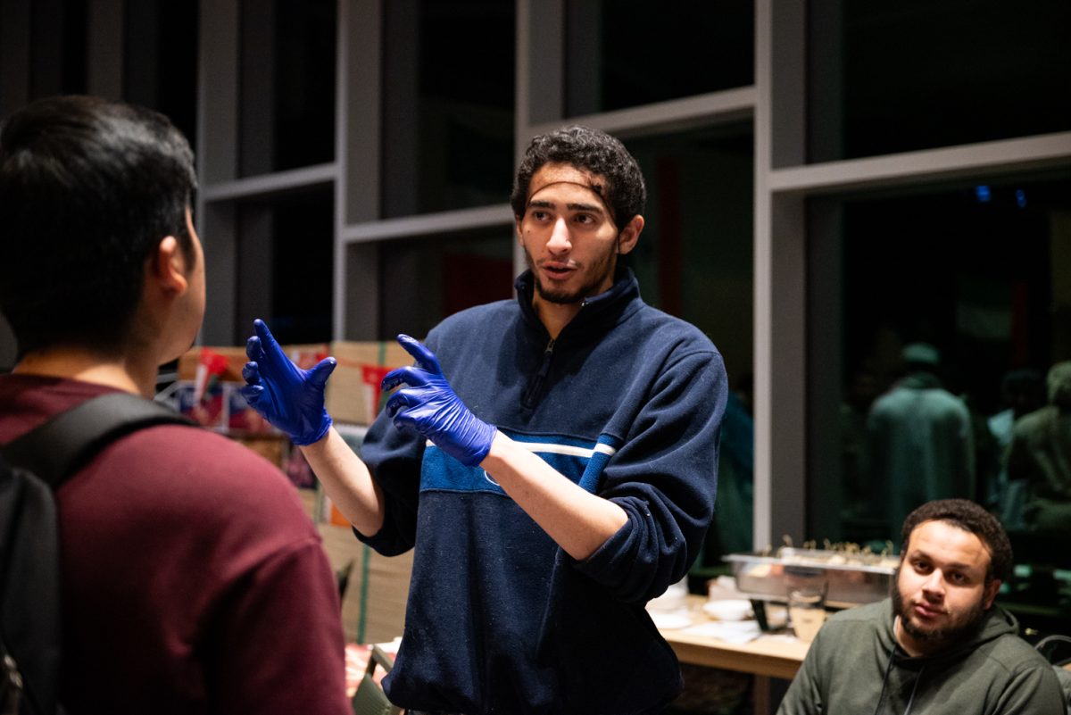 Muslim Student Association President Ali Eldeiry talks to a person visiting the association's booth at the World Unity Fair Feb. 17. "It feels great," Eldeiry said. "We got a lot of people who were interested, a lot of people coming and asking questions."