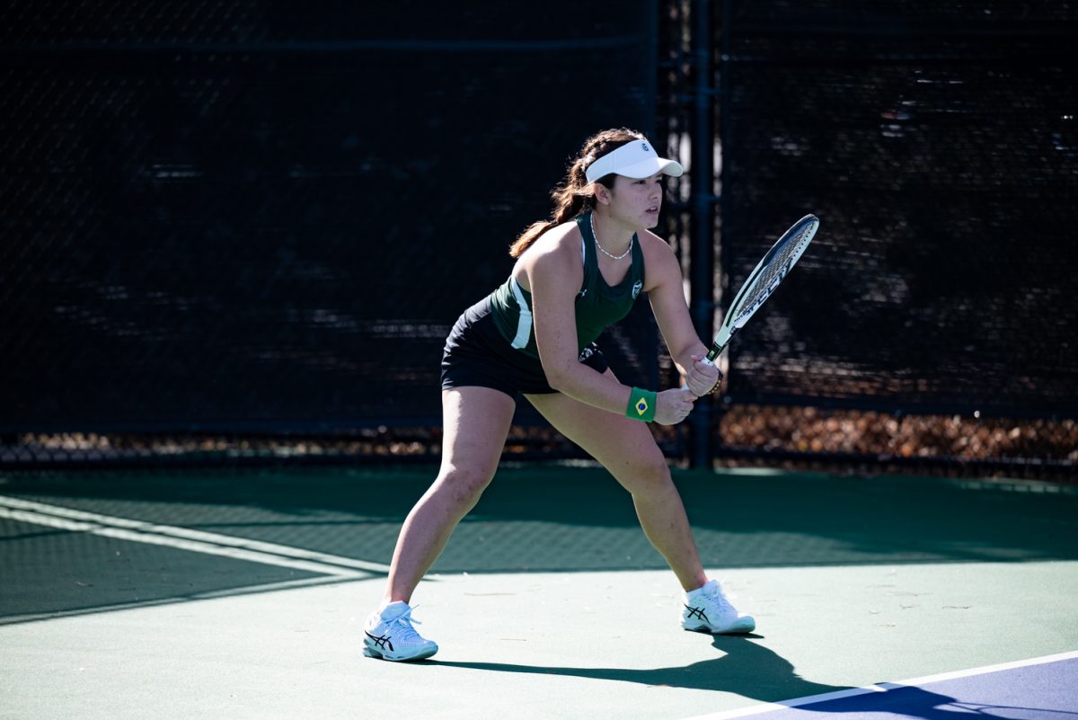 Sophomore Luana Avelar prepares for a serve during a singles match against Northern Arizona University.