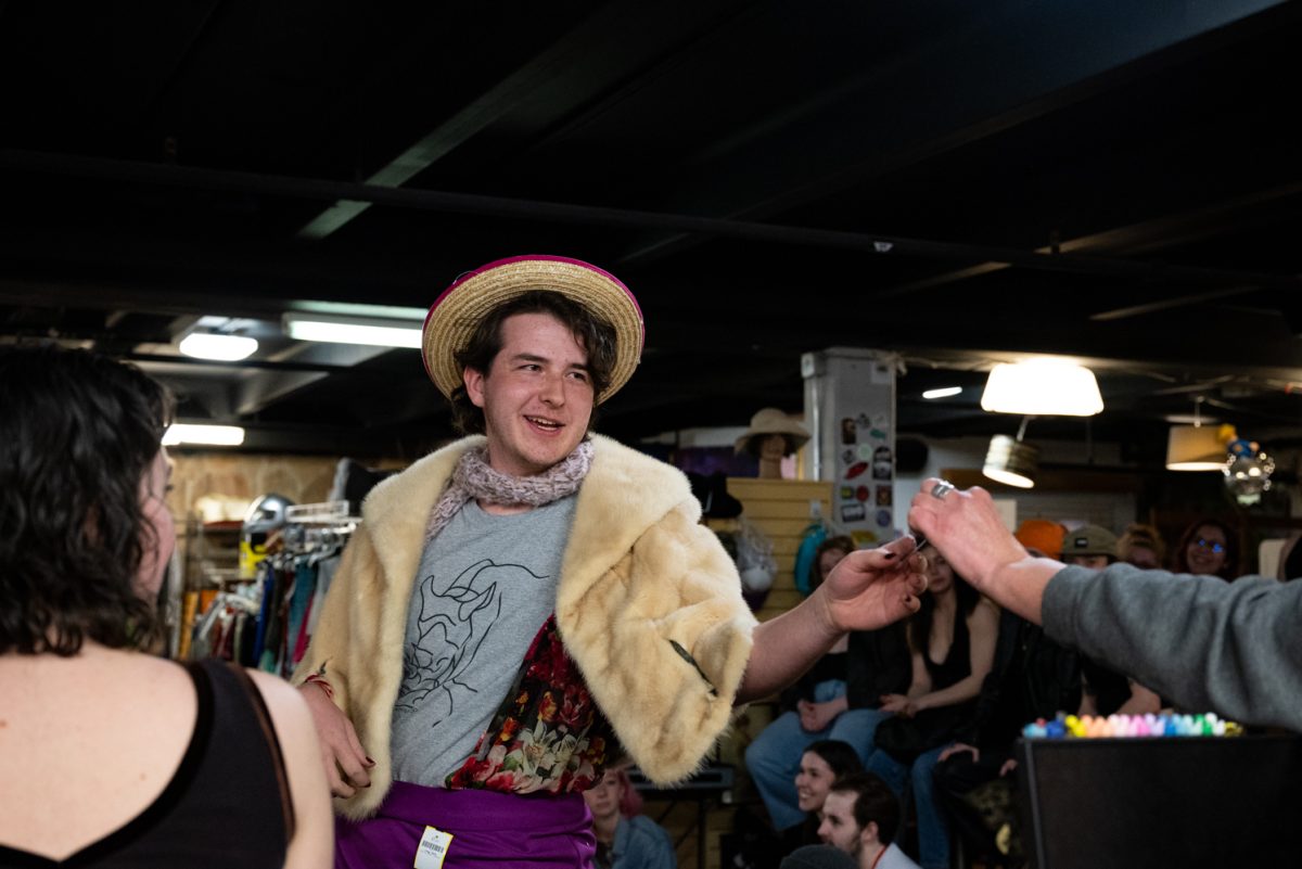 A volunteer from the audience collects a prize from Eco Thrift owner Stacey Koeckeritz.