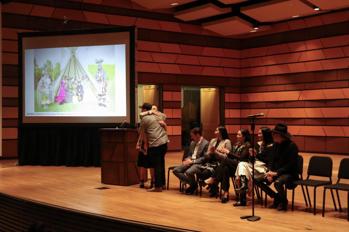 Norma Baker-Flying Horse (Red Berry Woman) embraces Joseph 'Sagonige Yanasi' Pekara (Pharaoh 171) after talking about their work together. At their artist talk at Colorado State University's Center for the Arts. Feb 15.