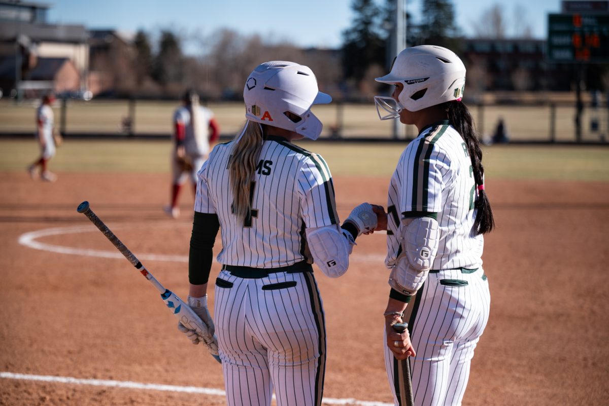 Molly Gates (4) and Danielle Serna (21) talk before going up to bat against Iowa State.