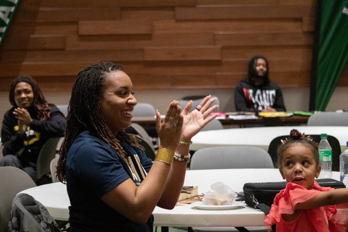 Destiny Hardney claps following a performance during Black History Month Closing Open Mic Night on February 29, 2024.