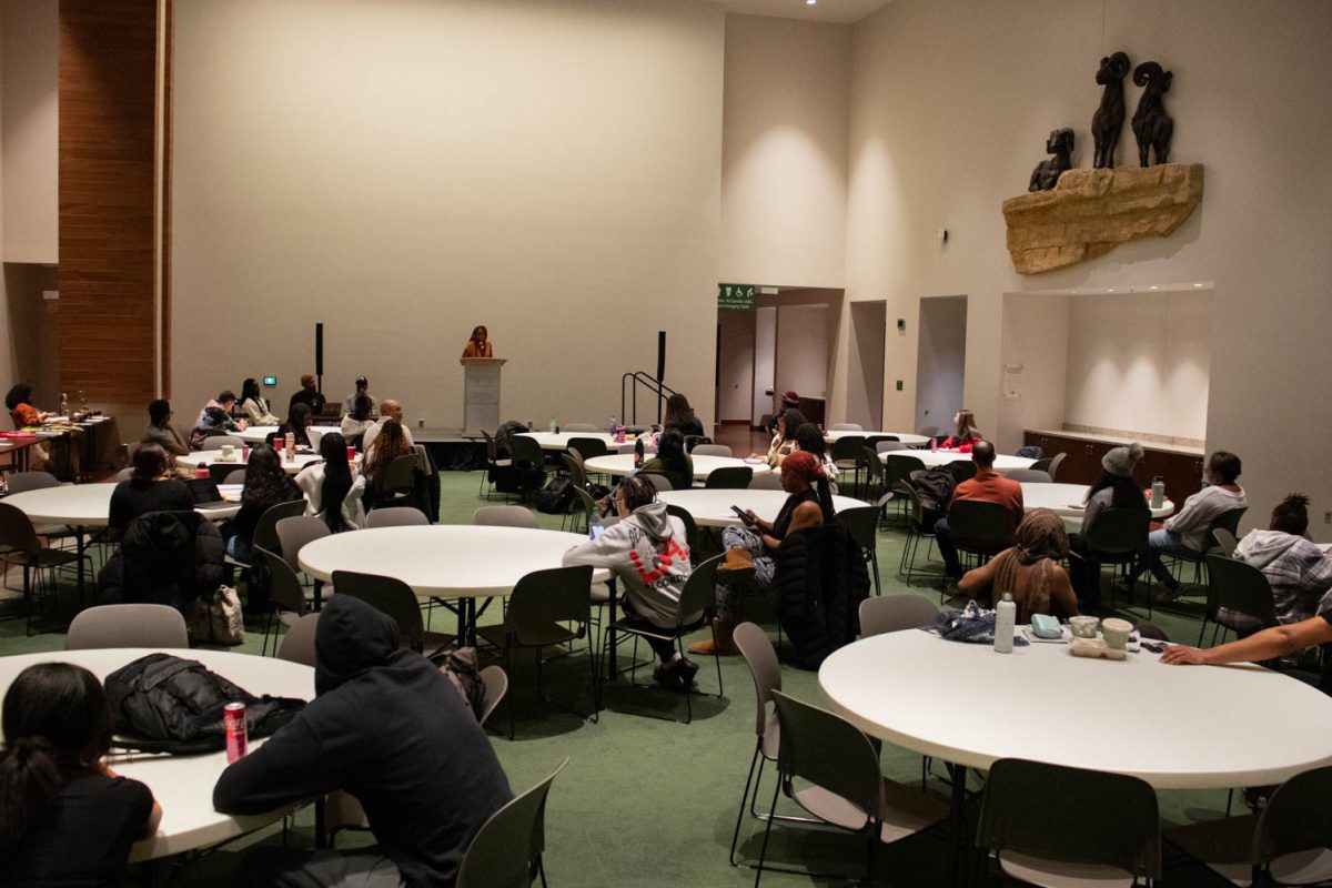 The crowd watches as Kylynn White reads her poem during the Black History Month Closing Open Mic Night on February 29, 2024.