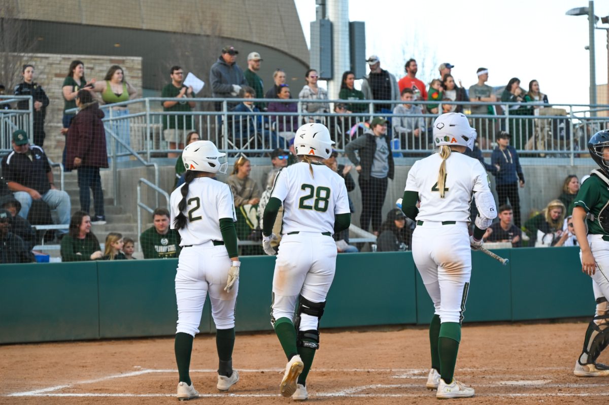 Colorado State University softball players Maya Matsubara (2),Kaylynn English (28) and Molly Gates (4) walk back to the dugout after all getting home during the CSU game against Manhattan College March 2. CSU won 13-5.