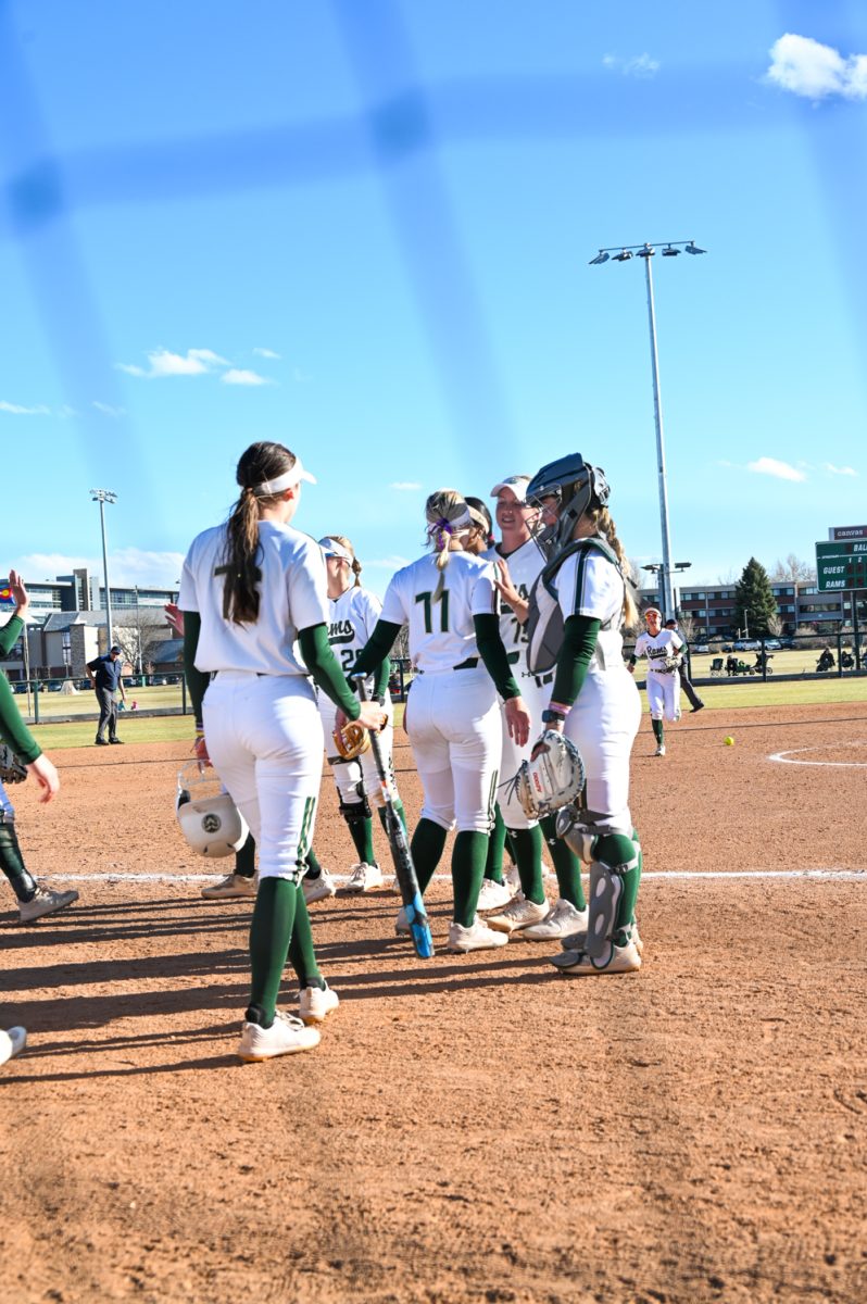 The CSU team huddles and celebrates another successful inning during the second game of the CSU vs. Manhattan doubleheader softball game on March 2, 2024. (CSU won 13-5)