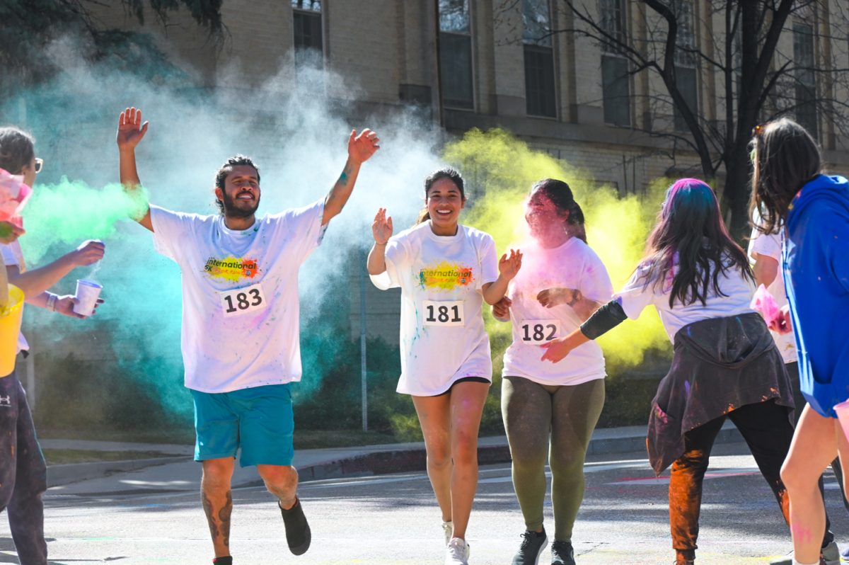 Three runners cross the International 5K Color Run finish line at The Oval March 23. The annual race is held at Colorado State University to raise money for international scholarship funds. 