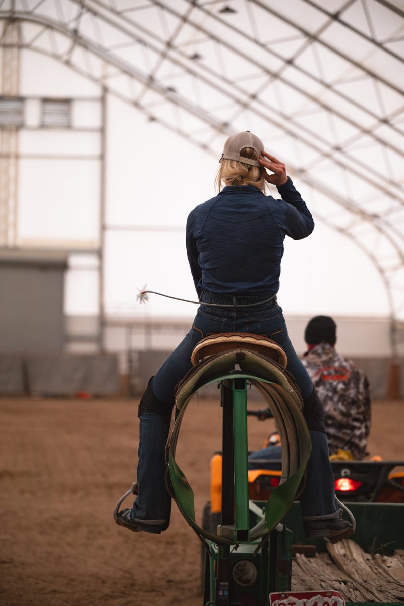 Sadie Johnson sits on a training barrel during Colorado State University rodeo team practice in Nuun, Colorado.