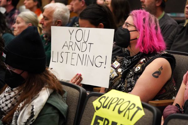 A Fort Collins city member holds up a sign reading “You Arndt Listening!” in a meeting called by Fort Collins City staff March 18.