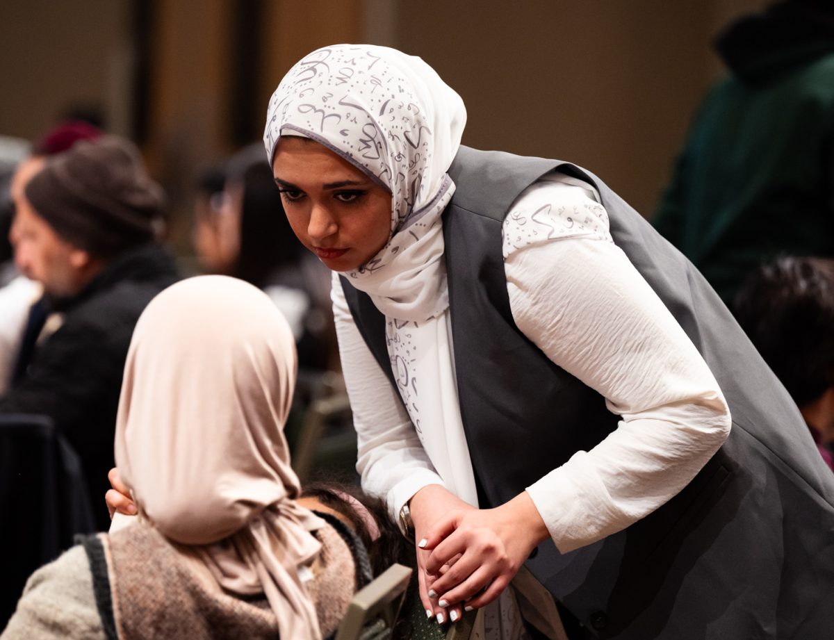 Reham Abdunabi, president of the Southwest Asian North African Student Organization, talks to an attendant of the Ramadan Iftar Dinner Event in the Lory Student Center.