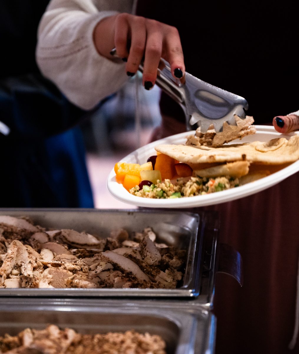 Attendants of the Ramadan Iftar Dinner Event begin getting food after a call to prayer in the Lory Student Center Ballroom.