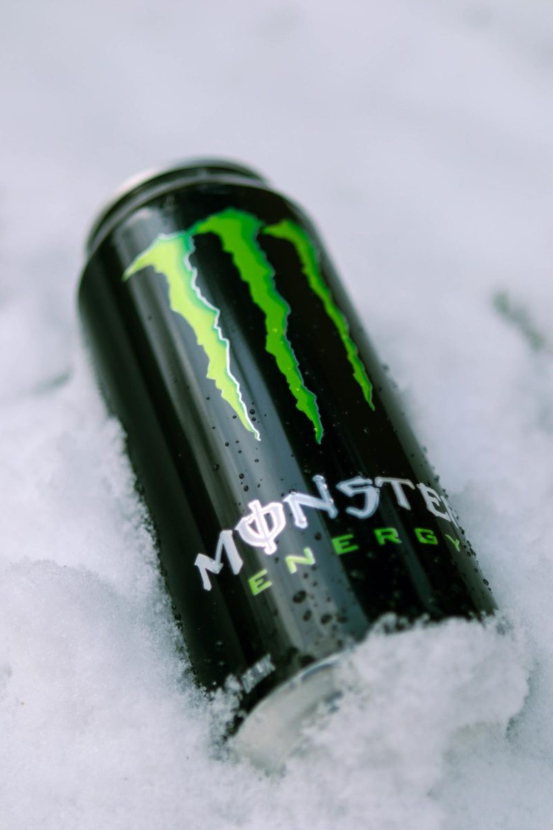 A Coca-Cola Monster Energy drink in the snow with water droplets scattered on the can. March 26.