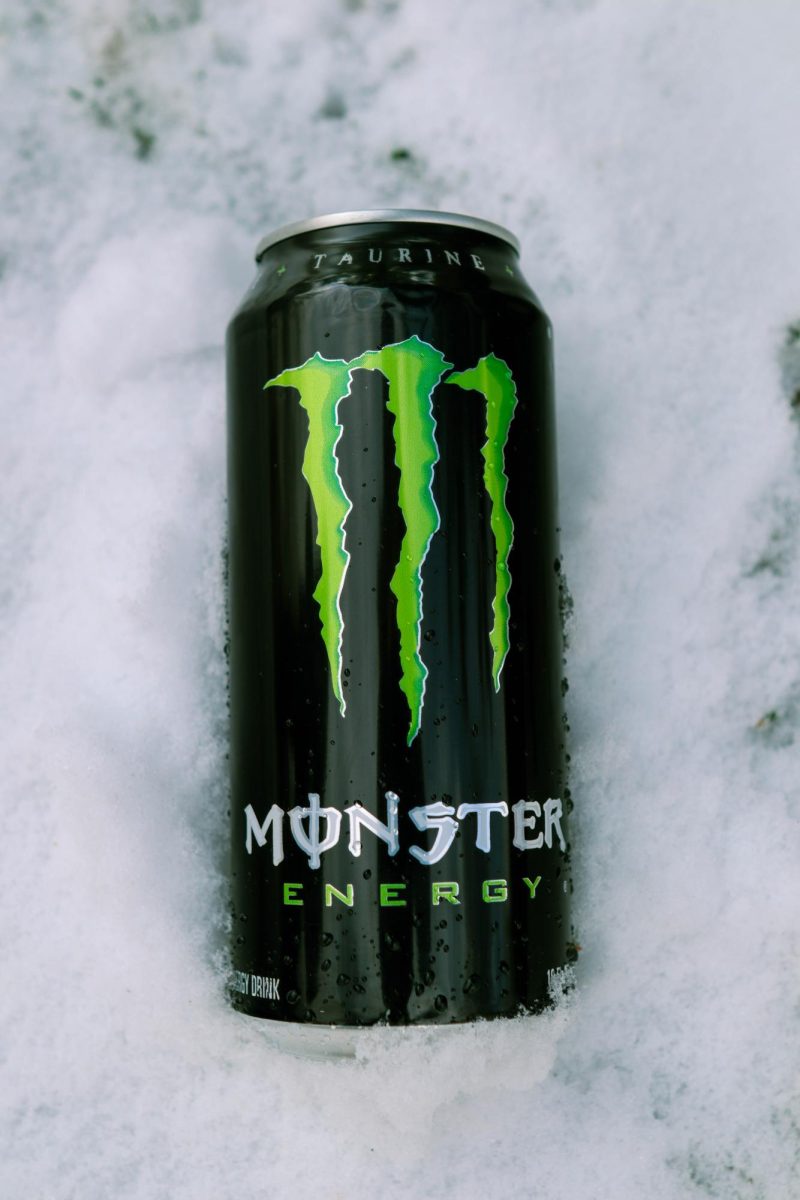 A Coca-Cola Monster Energy drink in the snow with water droplets scattered on the can. March 26.
