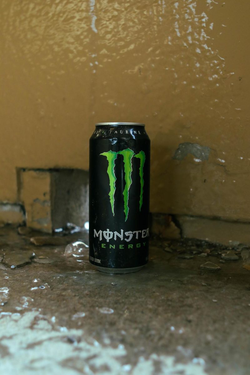A Coca-Cola Monster Energy drink sits on a puddle of ice against a breaking wall. March 26.