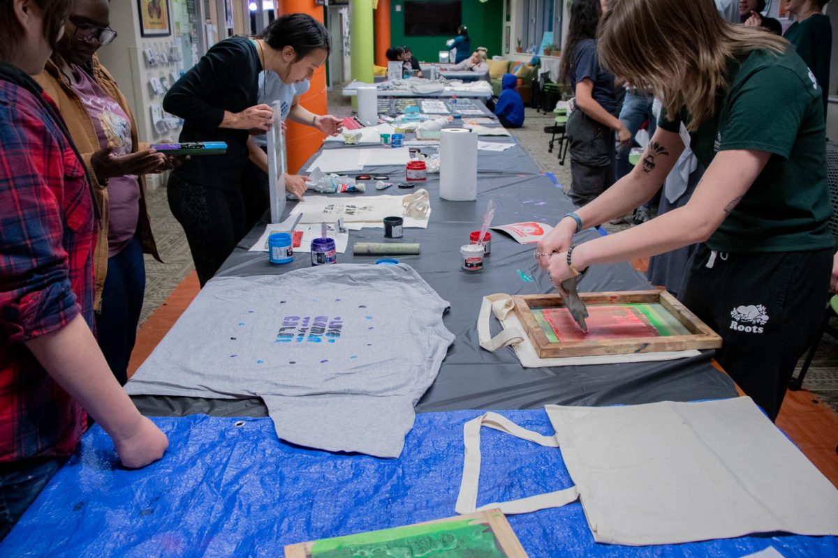 Participants work, in various stages, on their screen printing during the Love Women of Color: Celebrating Empowerment Through Art screen printing workshop April 18.