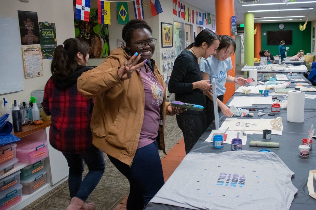 Markisha Olsen shows her messy fingers and her screen printed t-shirt during the Love Women of Color: Celebrating Empowerment Through Art screen printing workshop April 18.