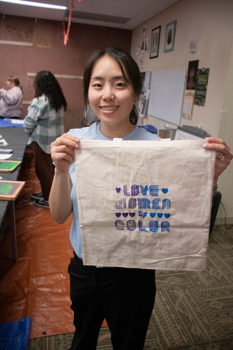 Seojung Lee holds up a tote bag that has her design screen printed on it during the Love Women of Color: Celebrating Empowerment Through Art screen printing workshop April 18.