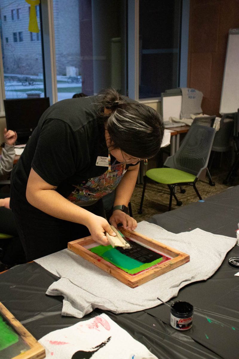 Rachel Wada, assistant director of the Asian Pacific American Cultural Center, swipes paint across a shirt during the Love Women of Color: Celebrating Empowerment Through Art screen printing workshop April 18.
