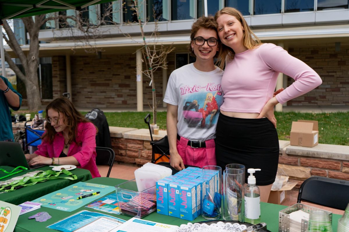 Associate Students of Colorado State University Vice President Alex Silverhart and ASCSU intern Lauren Johnson pose behind a table featuring free sexual healthcare products on the Lory Student Center Plaza Wednesday, April 24. 