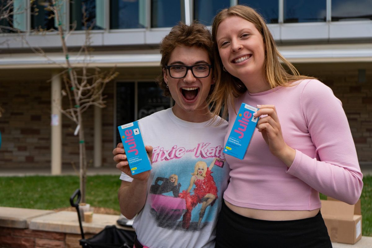 Associate Students of Colorado State University Vice President Alex Silverhart and ASCSU intern Lauren Johnson pose with free emergency contraceptives on the Lory Student Center Plaza Wednesday, April 24. 