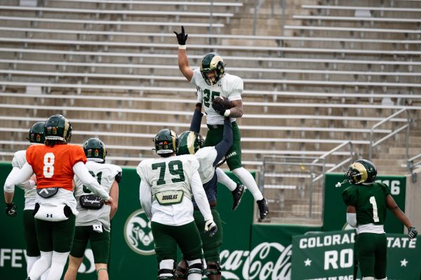 Graduate student Avery Morrow (25) is lifted into the air by a teammate after a touchdown during a spring football scrimmage.