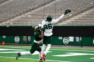 Sophomore Caleb Goodie (86) reaches to catch the ball before being tackled at a spring football practice.