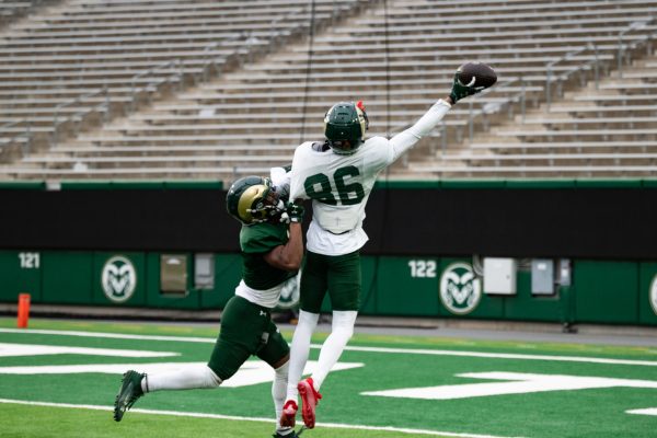 Sophomore Caleb Goodie (86) reaches to catch the ball before being tackled at a spring football practice.