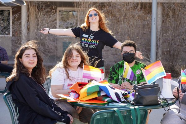 Isabel Brown, Alice Lister, Lauren Levine, and Emil Jarza pose for a photo while setting up flags and signs before they march to the Fort Collins Museum of Art for Night of Noise April 12.