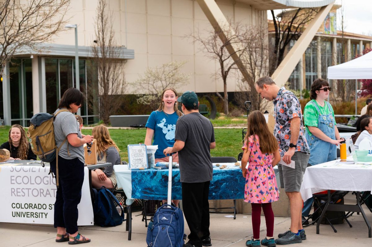 Mica Kimmett talks to students and the public about ocean pollution and gives out trivia for others to win prizes during the Colorado State University Earth Day festival on April 22.