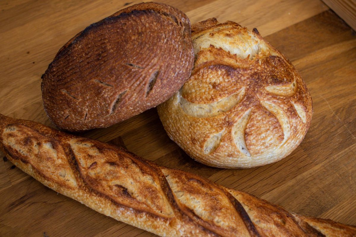 The Bread Chic, a Fort Collins local bakery offers freshly baked pastries and breads Monday through Sunday. A Rye loaf, Rosemary sourdough loaf, and Baguette are shown stacked on top of one another. Apr. 8.