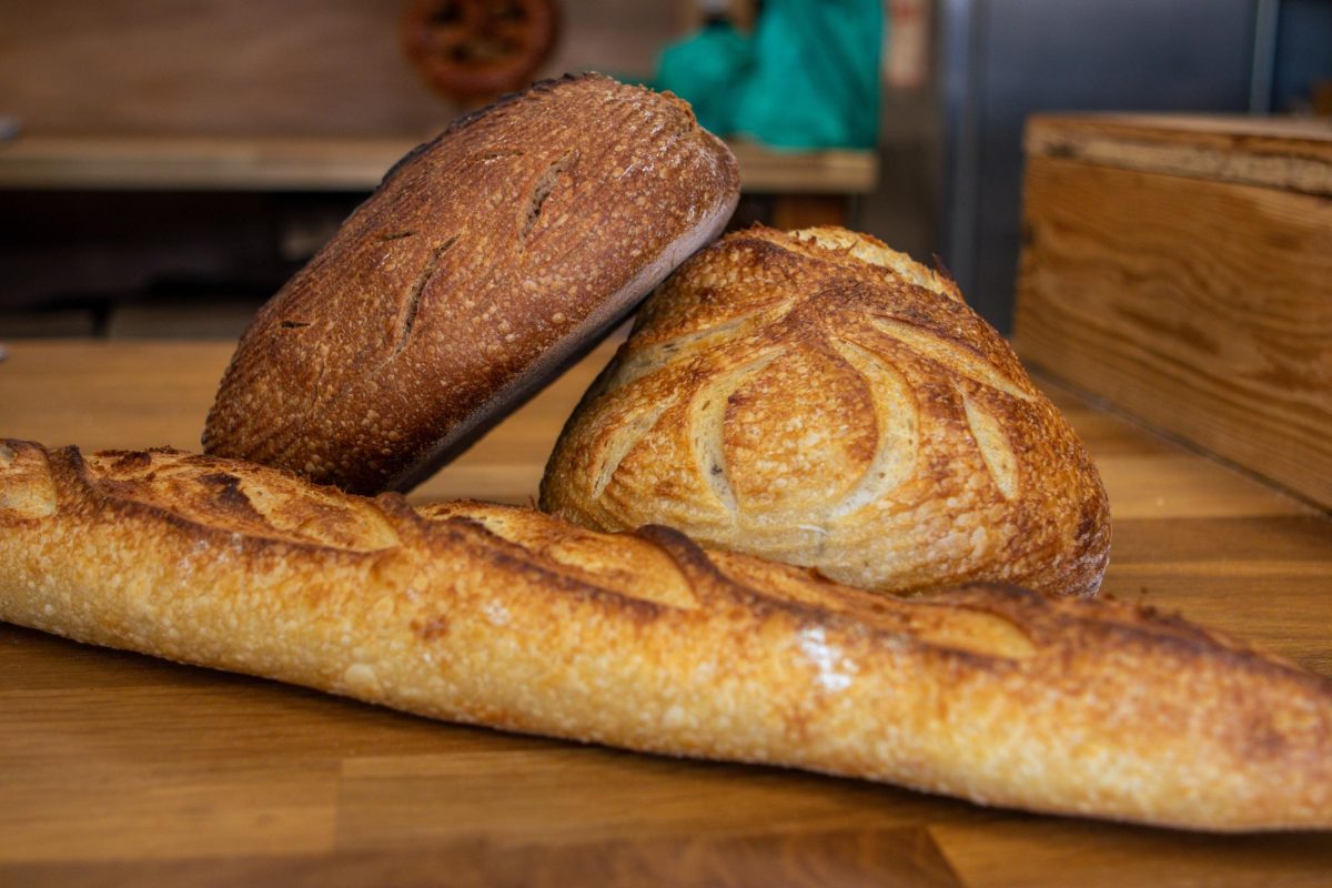 The Bread Chic, a Fort Collins local bakery, offers freshly baked pastries and breads every day April 8. A rye loaf, rosemary sourdough loaf and baguette are shown stacked on top of one another. 