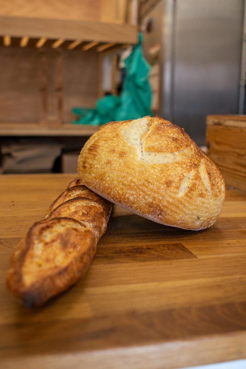 A freshly baked rosemary sourdough loaf and baguette are shown on a counter at The Bread Chic April 8.
