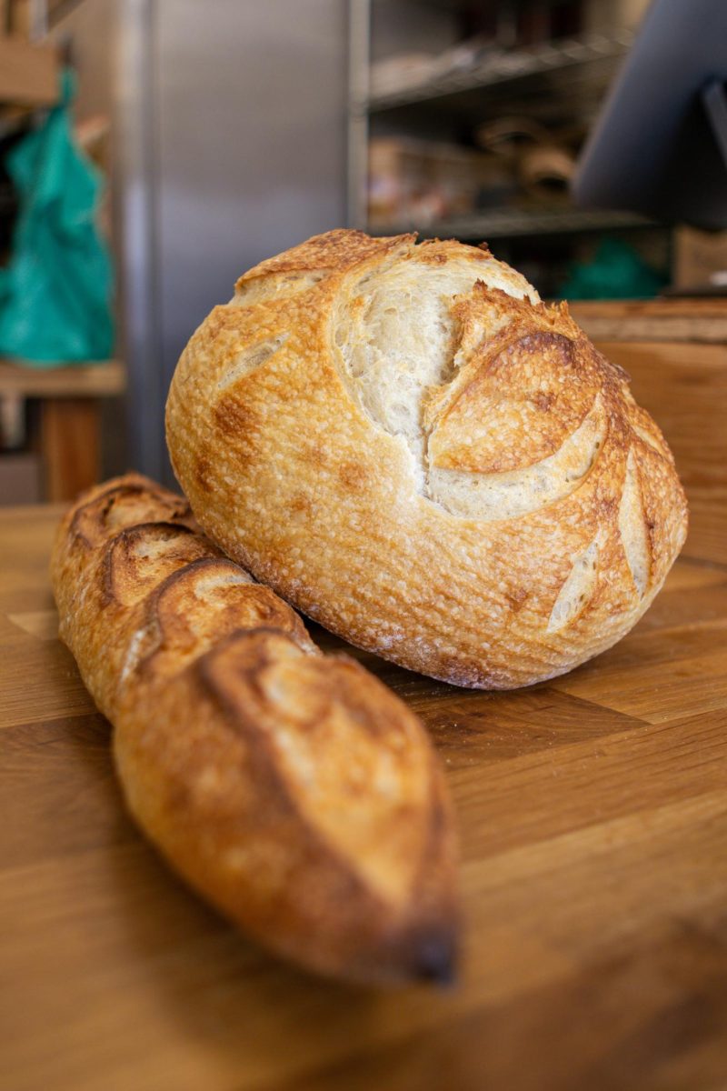 A freshly baked Rosemary sourdough loaf and baguette are shown on a counter at The Bread Chic. Apr. 8.
