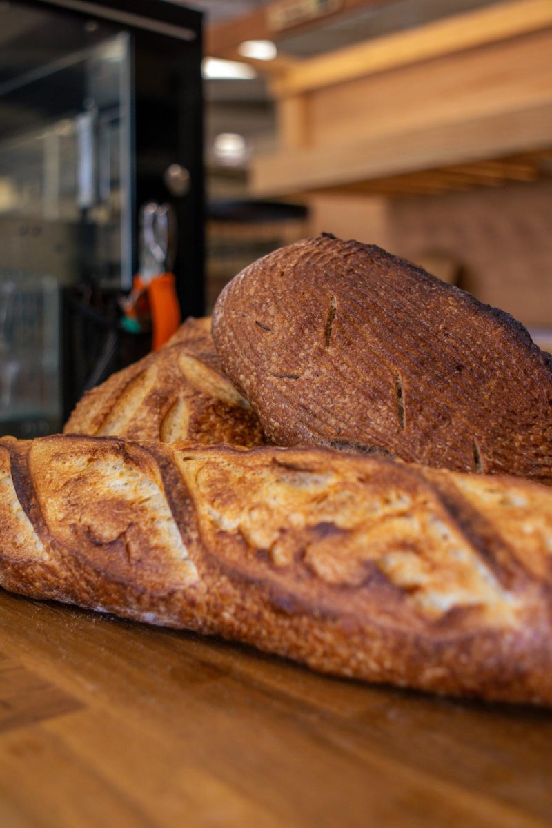 The Bread Chic, a Fort Collins local bakery offers freshly baked pastries and breads Monday through Sunday. A Rye loaf, Rosemary sourdough loaf, and Baguette are shown stacked on top of one another. Apr. 8.